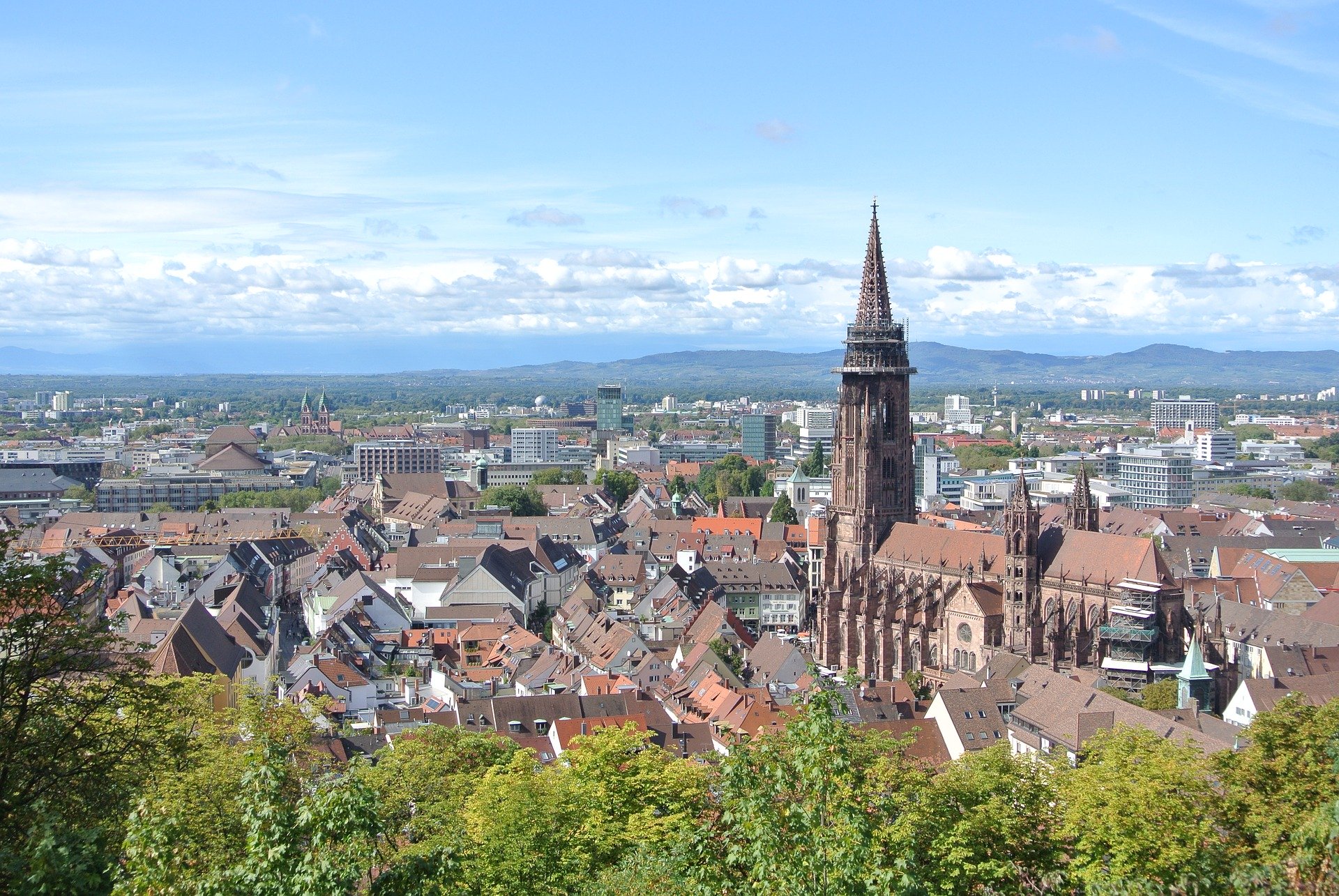 Blick über die Freiburger Altstadt auf das Münster, dahinter der Kaiserstuhl